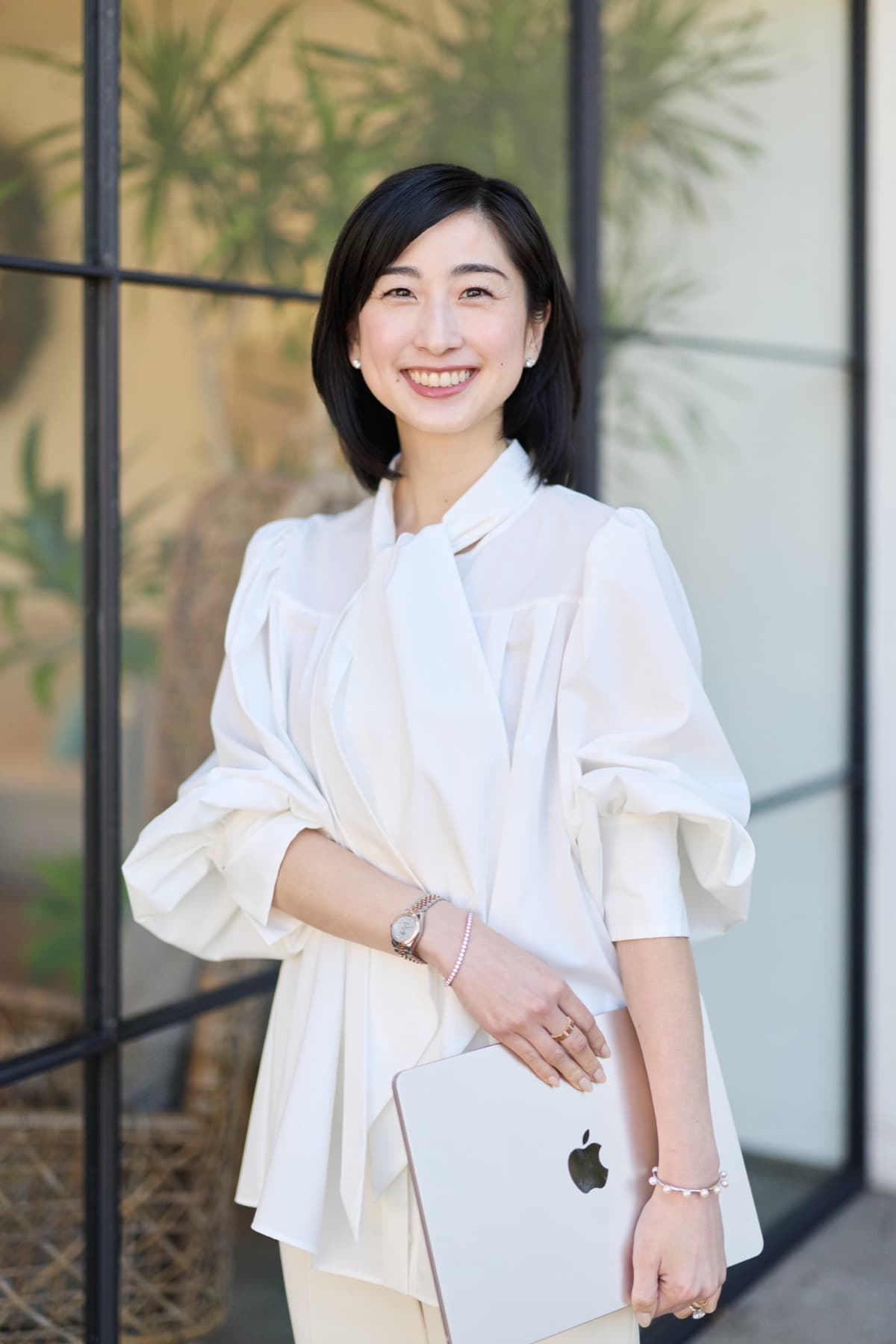 MacBookを手に立つ田中泉